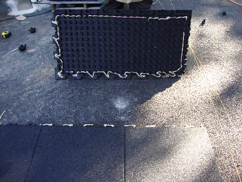 Showing glue on the outside edge of each tile being installed on solid sub-base