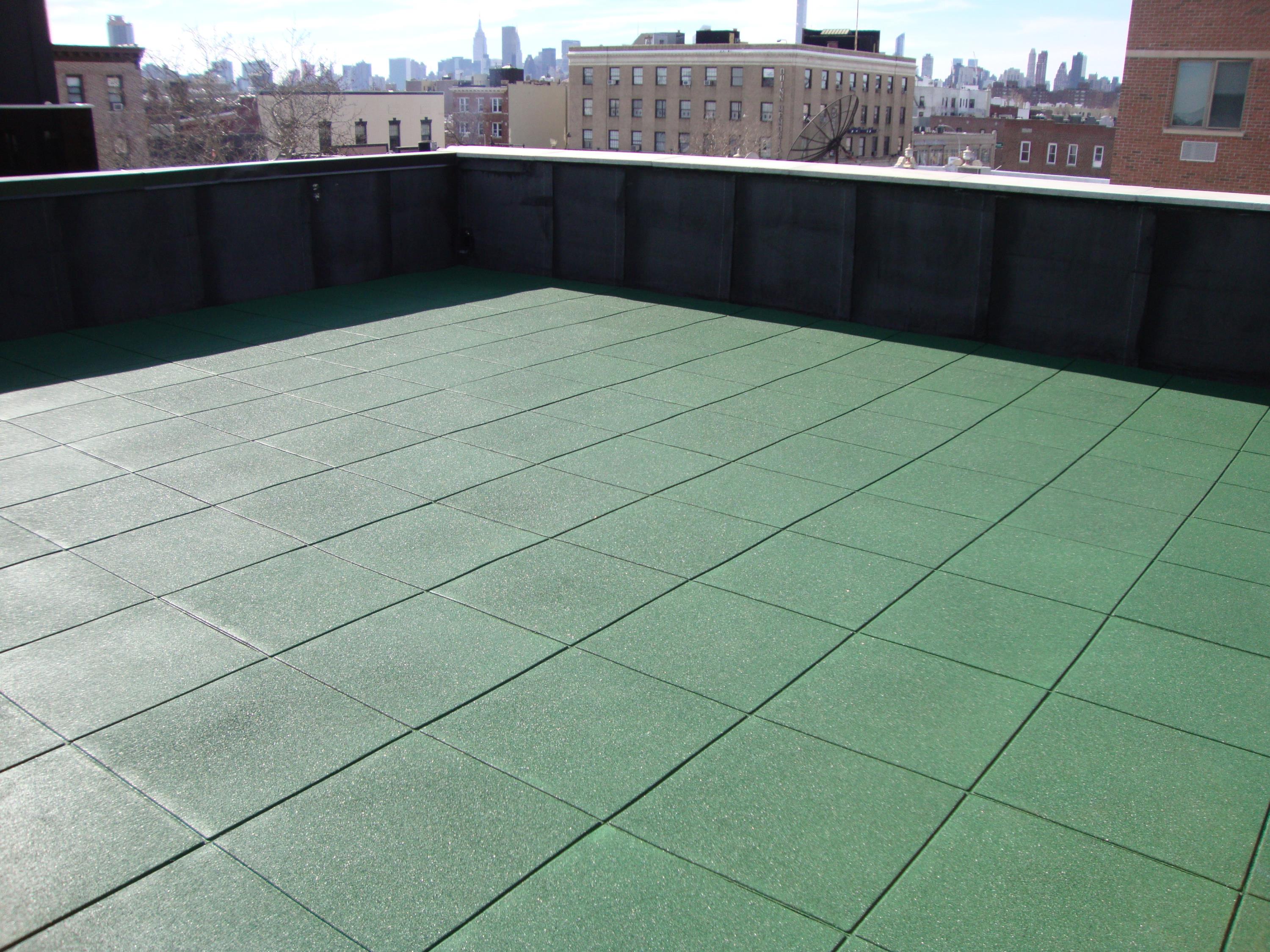 Residential roof deck on top of building using 2" thick green rubber pavers